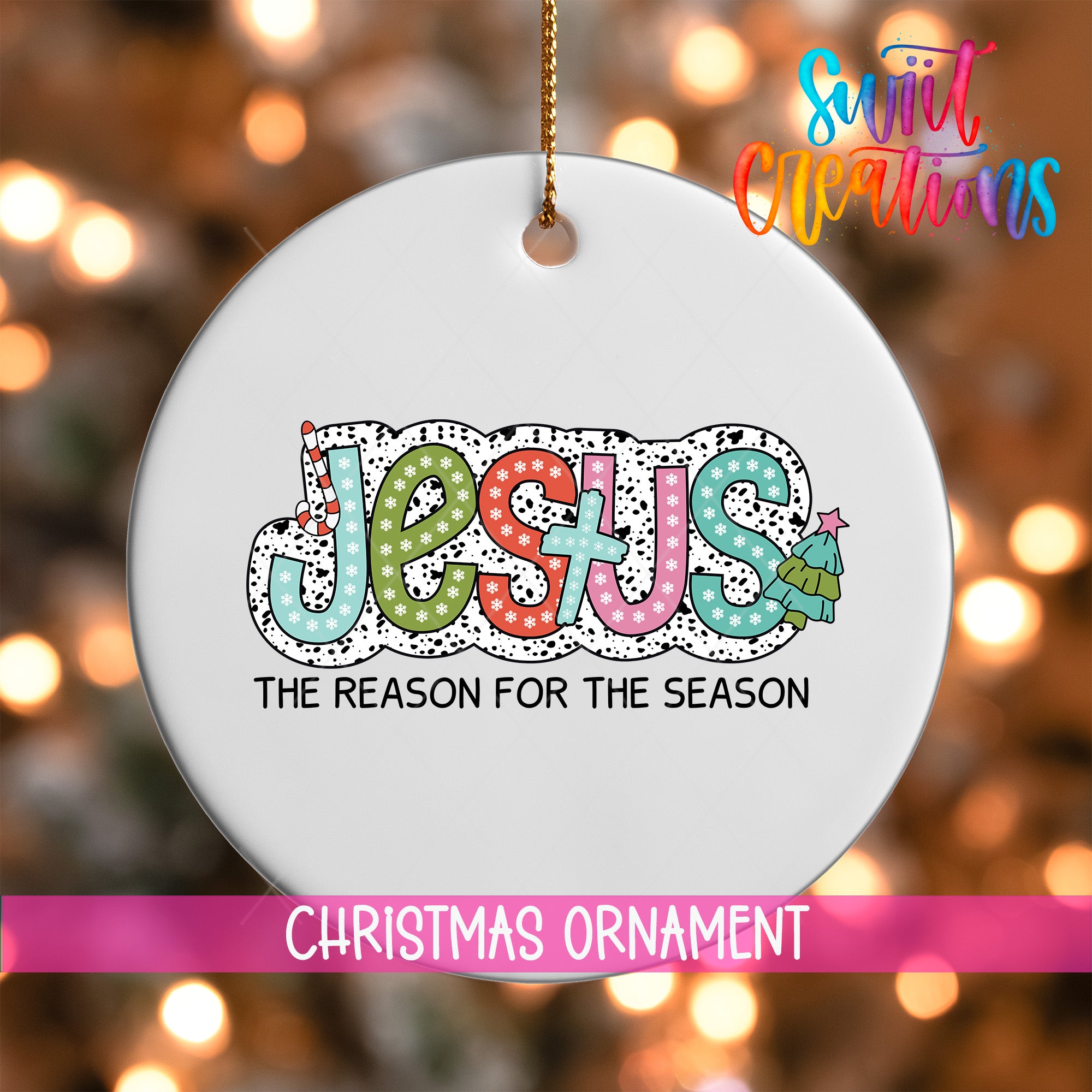 A white Christmas ornament with the word "JESUS" written in colorful letters, along with the text "THE REASON FOR THE SEASON" below it.