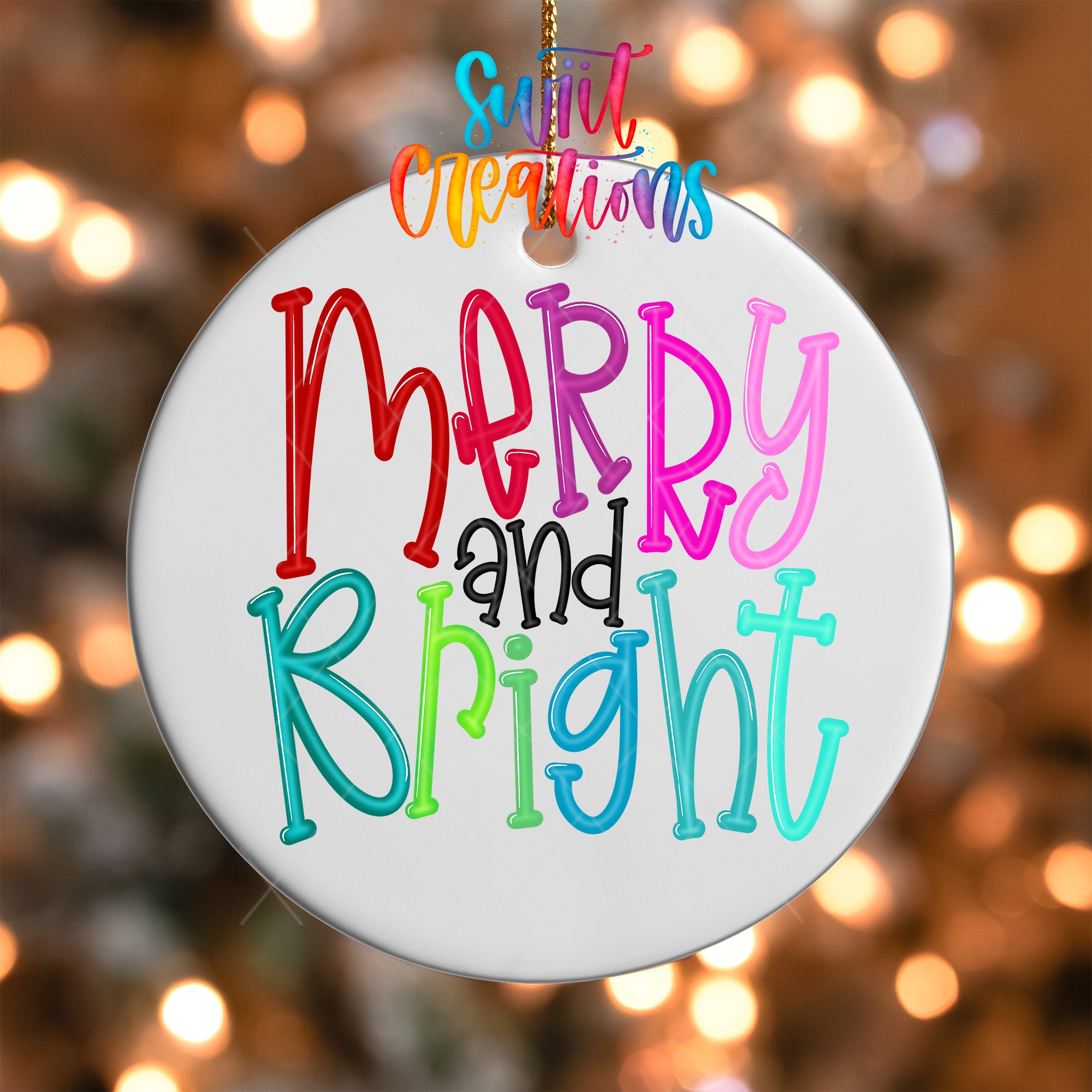 A white ornament with colorful text that says "Merry and Bright" hanging against a blurred background with twinkling lights.