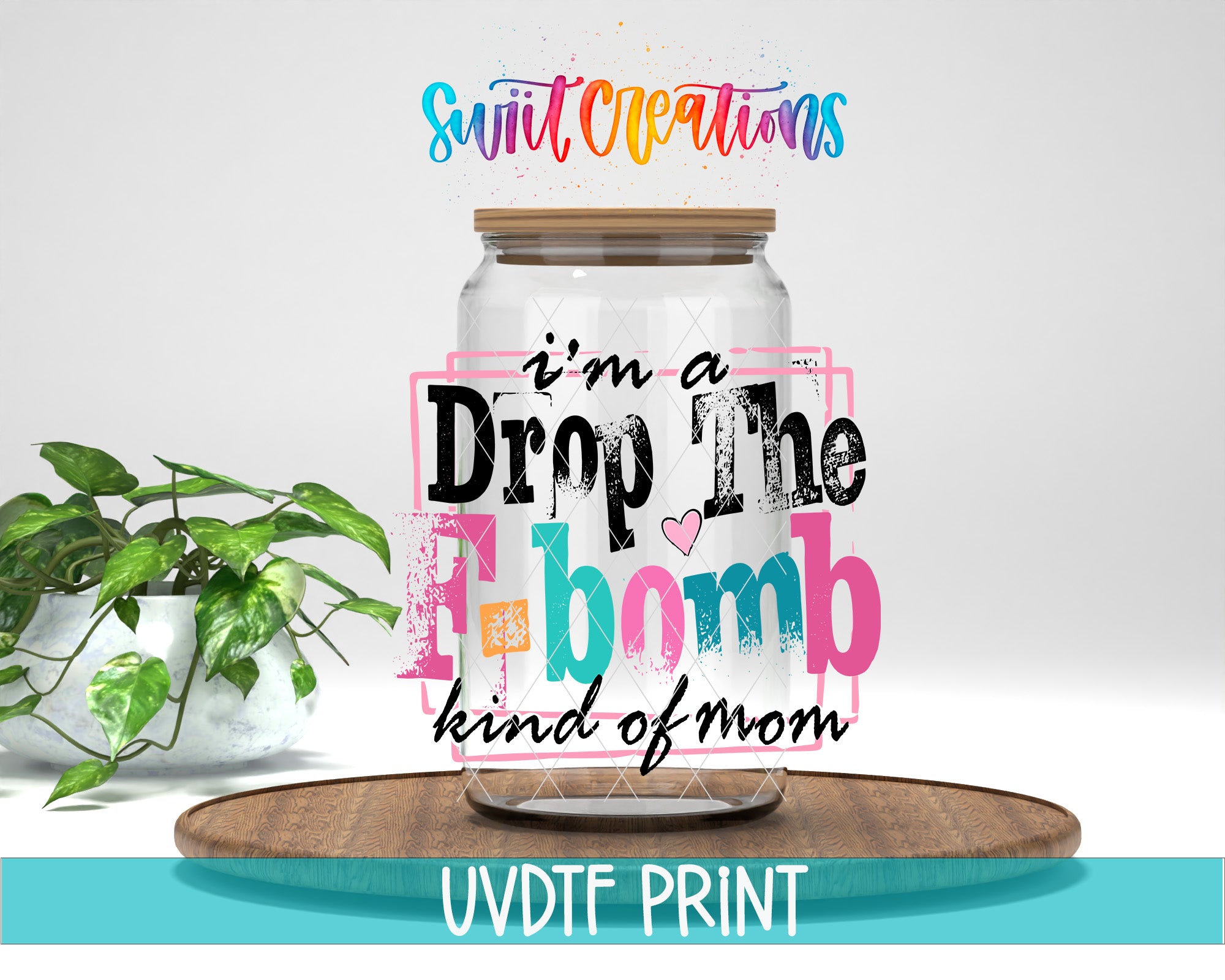 a glass jar with a wooden lid, surrounded by a potted plant and a wooden tray. The text on the jar reads "I'm a Drop The F- bomb kind of mom" and is accompanied by a colorful, stylized design.
