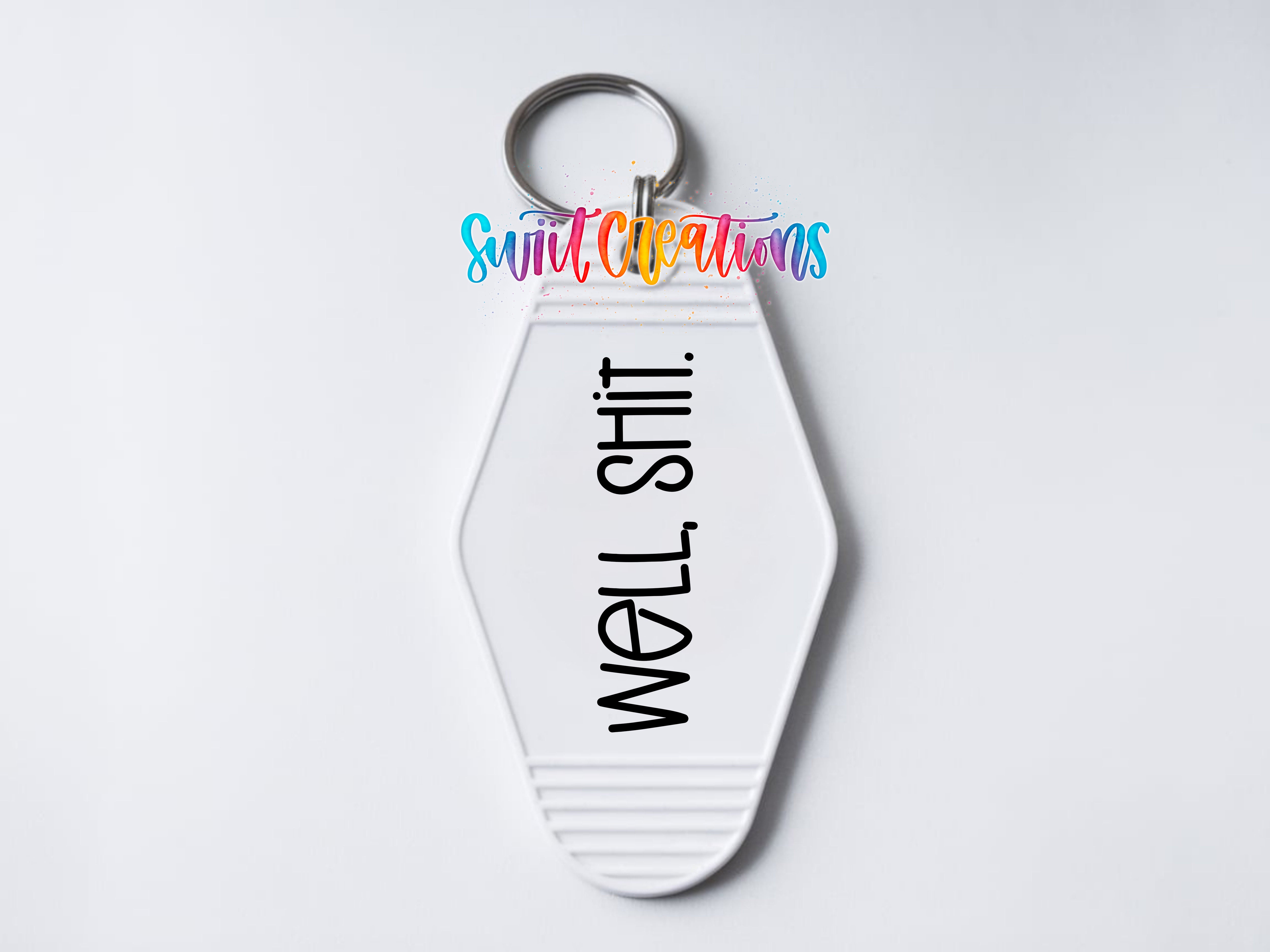 A white keychain with the text "WELL SHIT" printed on it.