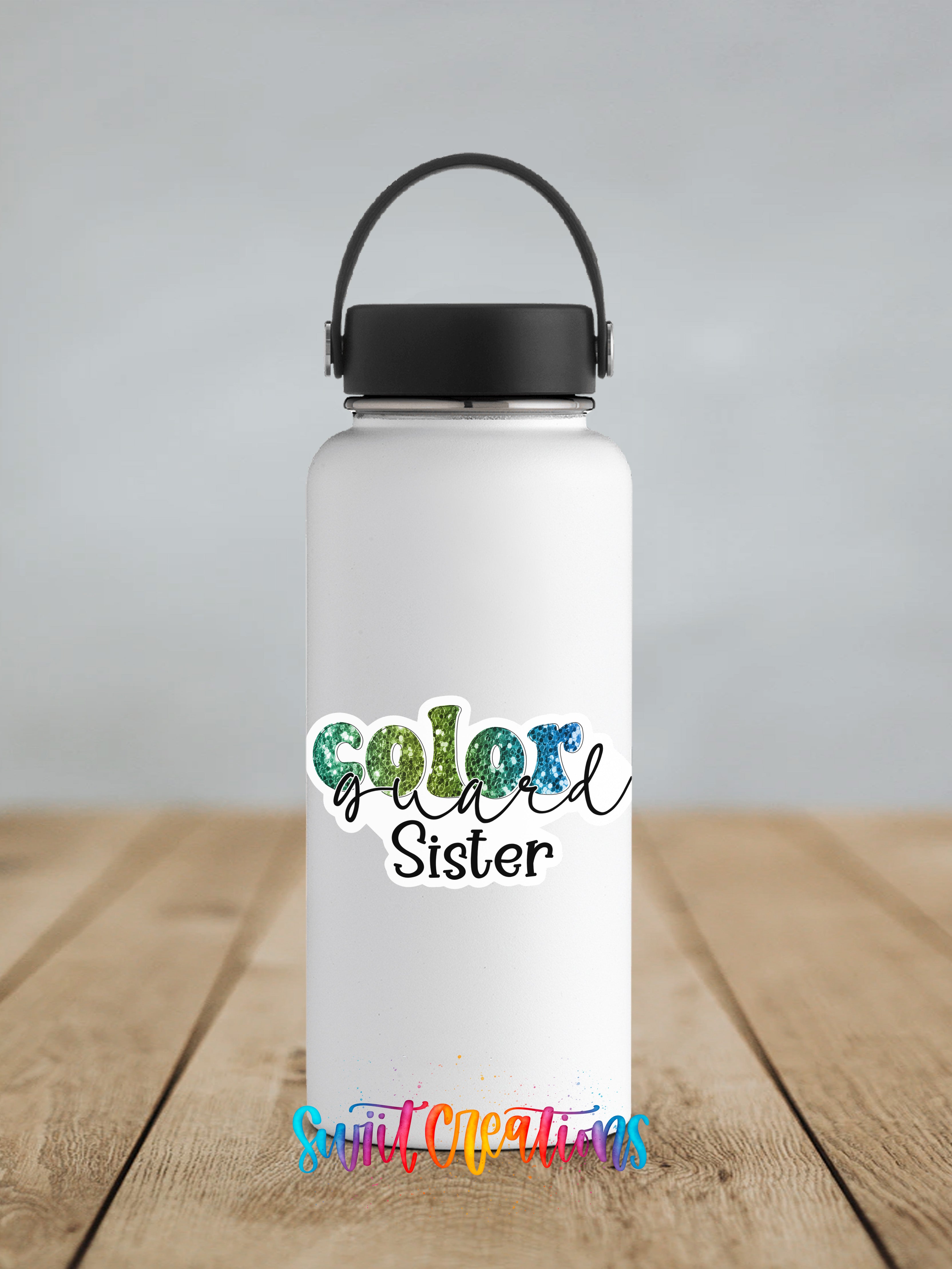 A white water bottle with a black handle and a colorful text logo that says "Color Sister" on it, placed on a wooden surface.