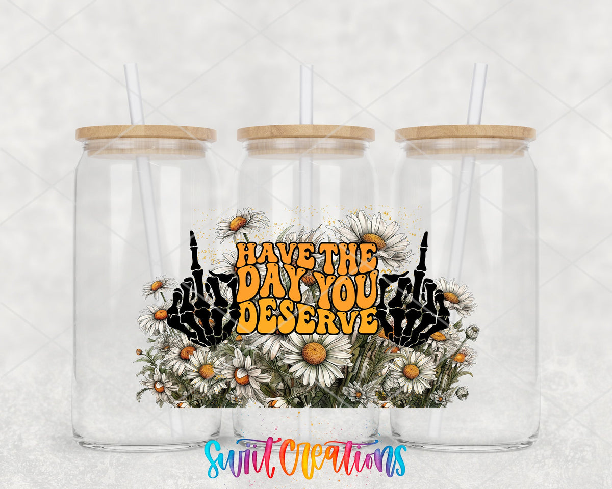 Have the Day You Deserve skeleton hands and daisies UV DTF wrap on three glass cans