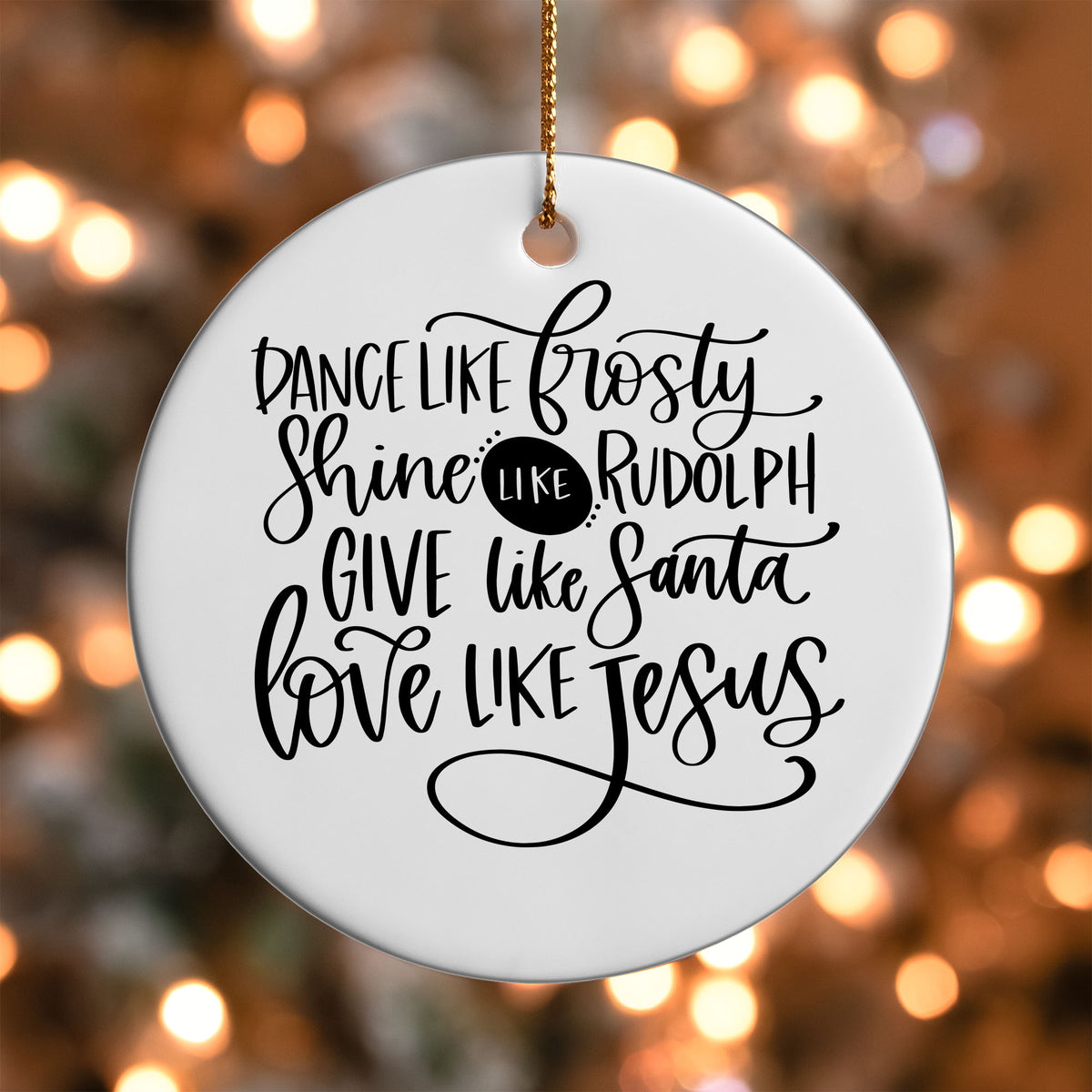 Dance Shine Give Love ornament UV DTF transfer on a round white ornament with a bokeh light background