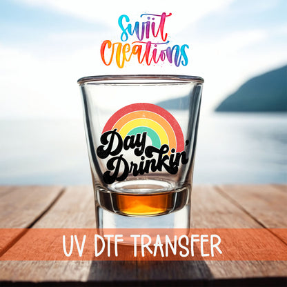Day Drinkin' shot glass UV DTF transfer on a filled shot glass on a dock by the water