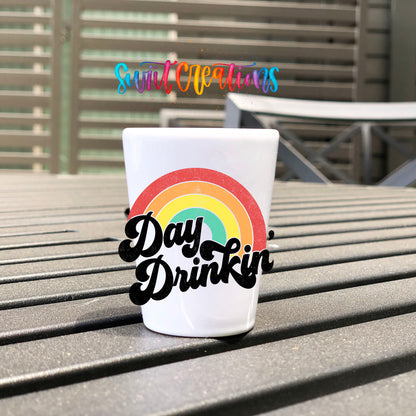 Day Drinkin' UV DTF transfer on a white shot glass on an outdoor patio table