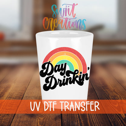 Day Drinkin' shot glass transfer on a white shot glass on a wooden table