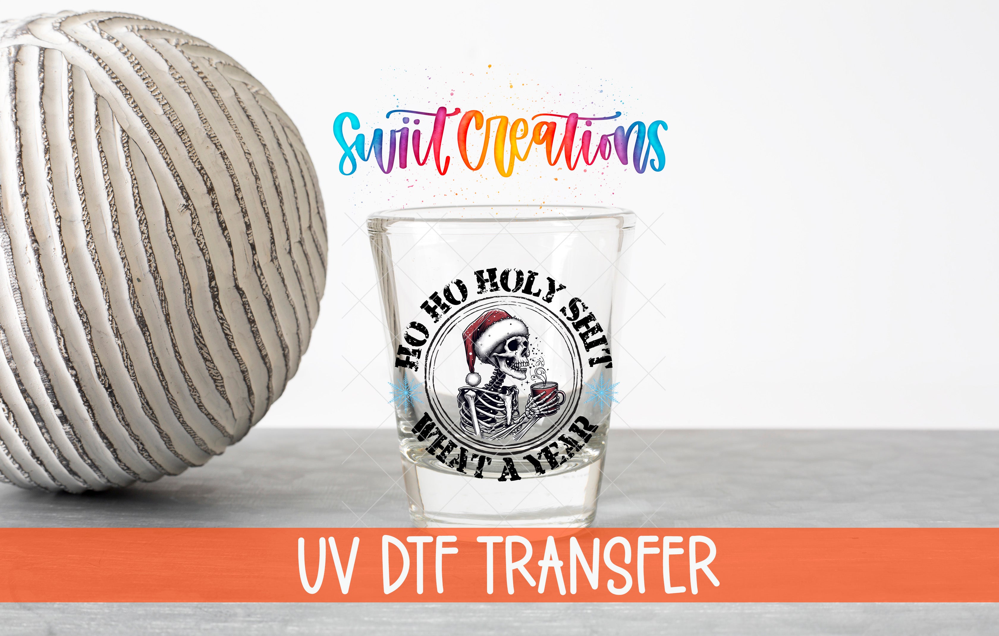 a glass with a skull and crossbones design, along with the text "Hoo ho holy shit what a year" and "UV DFT Transfer" written below it.