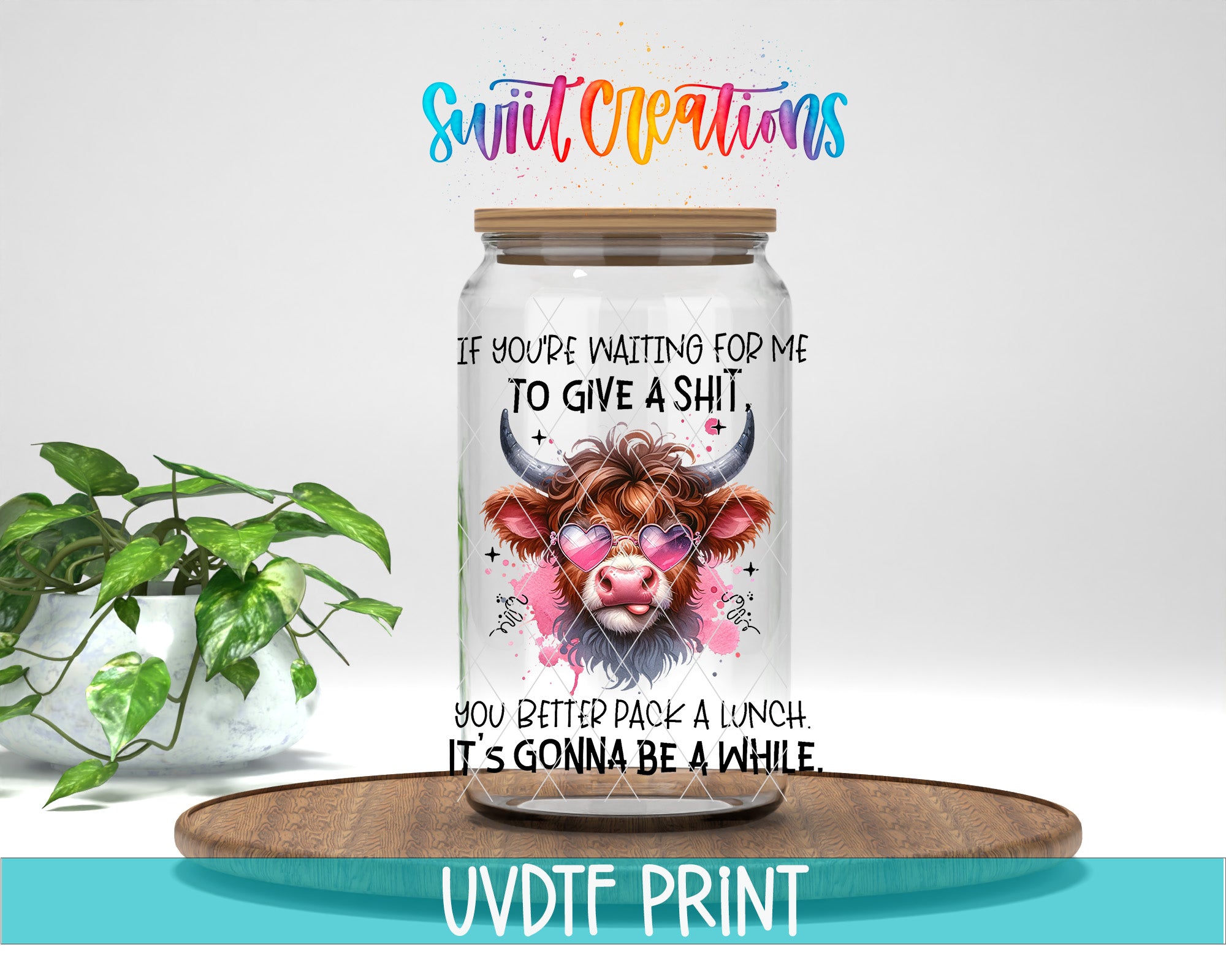 a glass jar with a cow's face on it, placed on a wooden surface. The jar has a lid and a label with text on it. The background of the image is white, and there is a plant visible in the background.