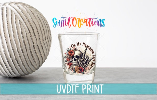 a ball of yarn next to a shot glass