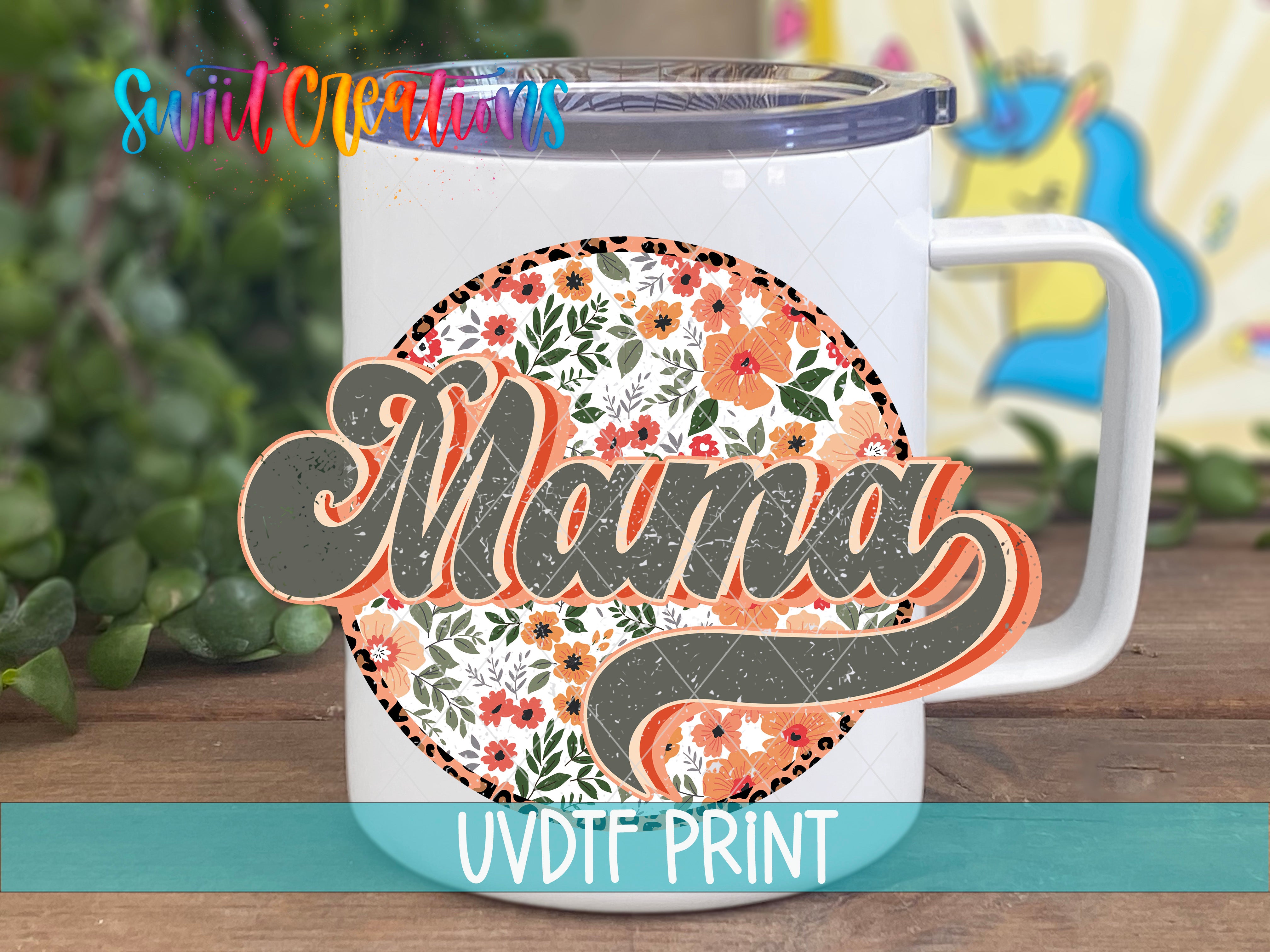 A white ceramic mug with a floral design and the word "Mama" printed on it, placed on a wooden surface.