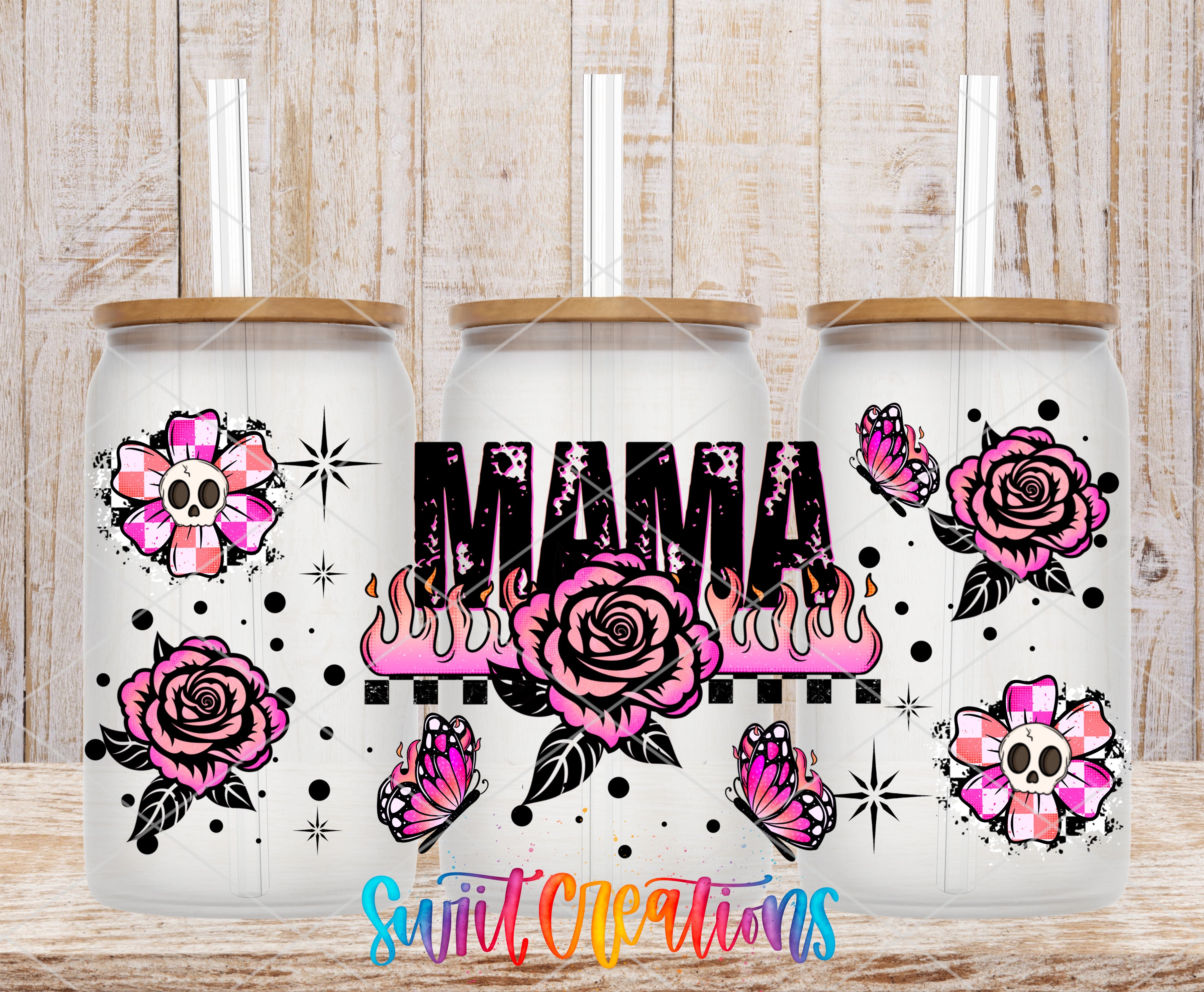 three glass tumblers with various floral and skull designs, including roses, butterflies, and skulls, arranged in a row against a wooden background.