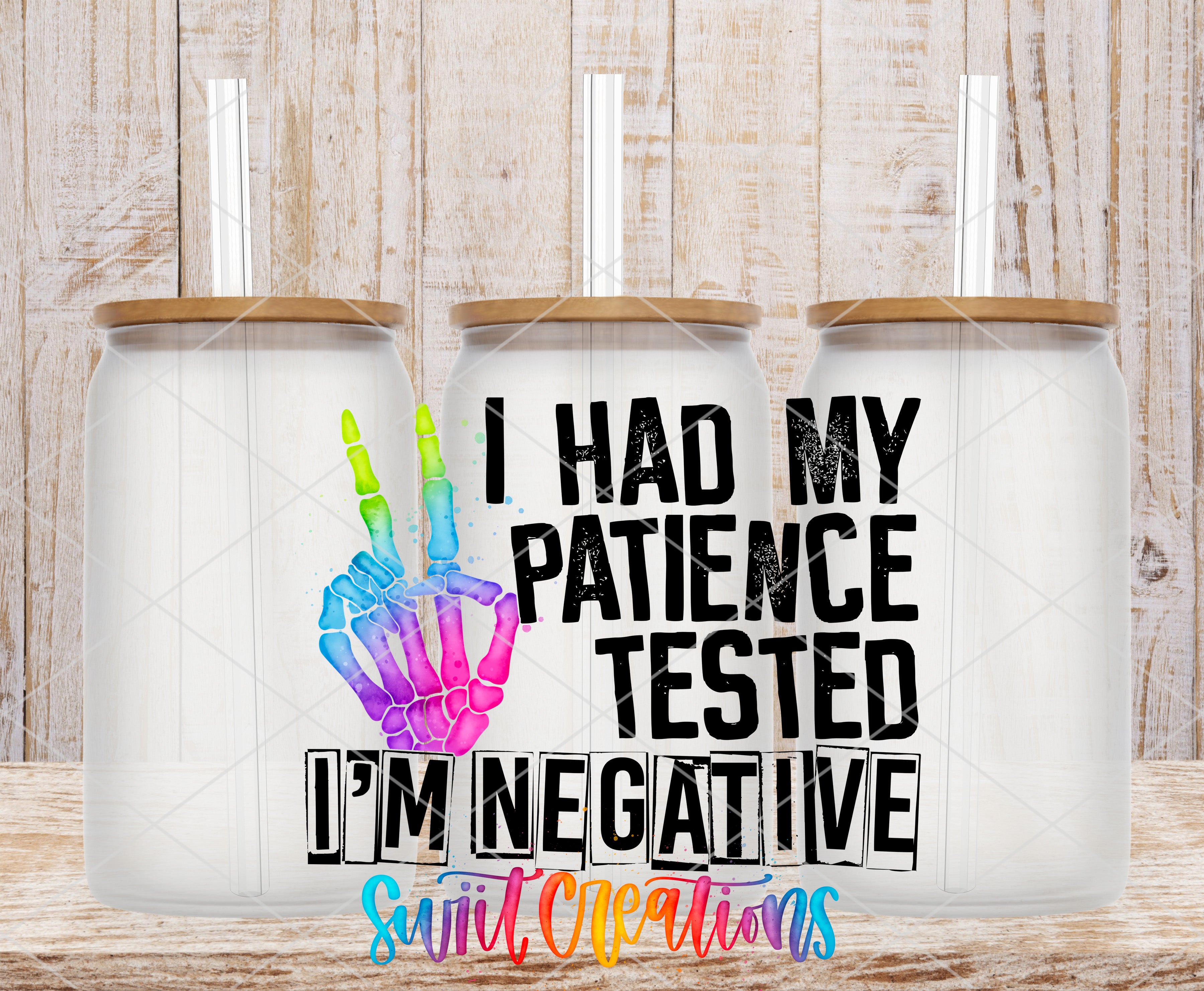three glass jars with a colorful skeleton hand design and text that reads "I HAD MY PATIENCE TESTED I'M NEGATIVE" and "Swift Creations".