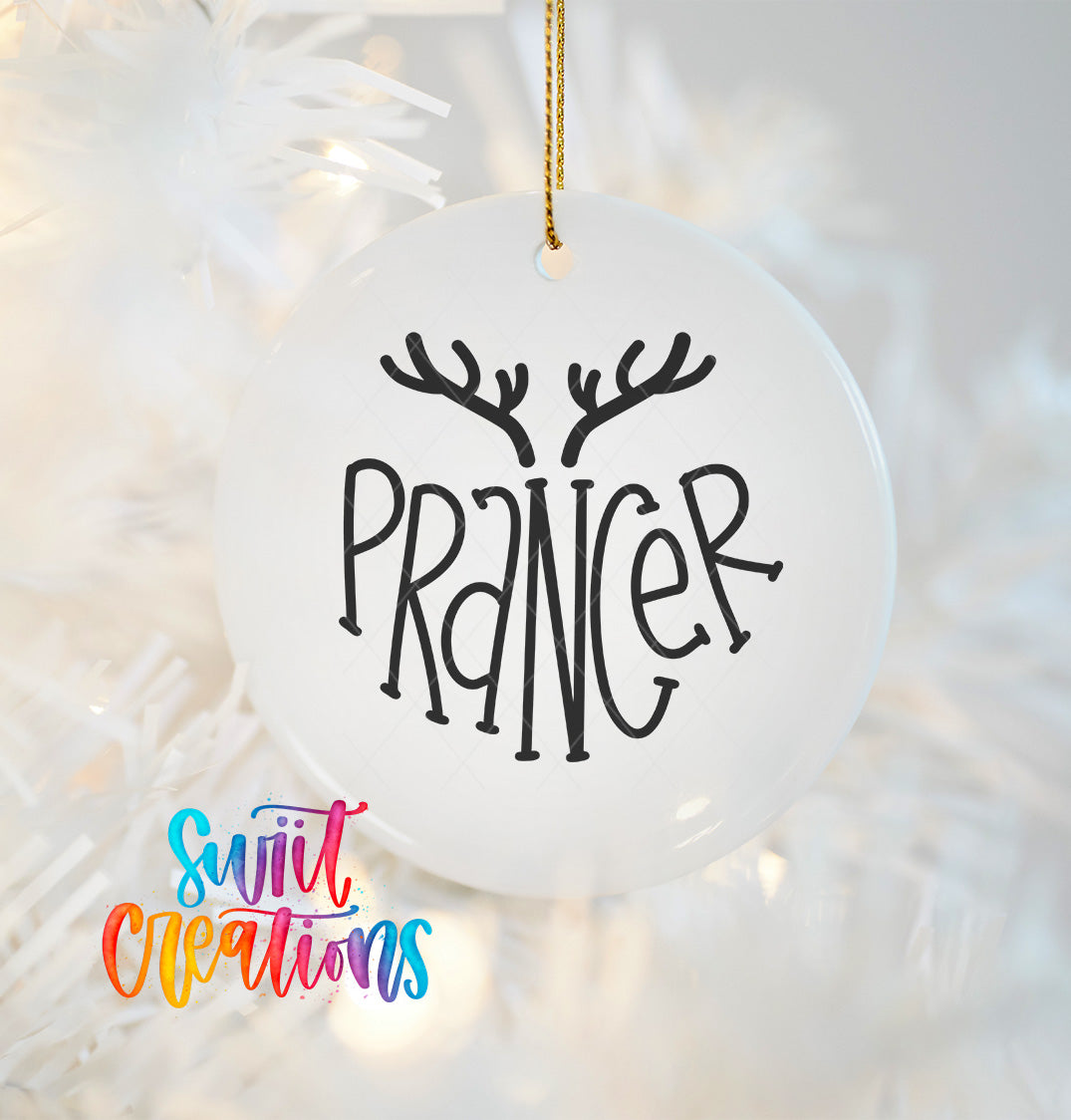 A white ornament with the word "Prancer" written on it, hanging on a Christmas tree.
