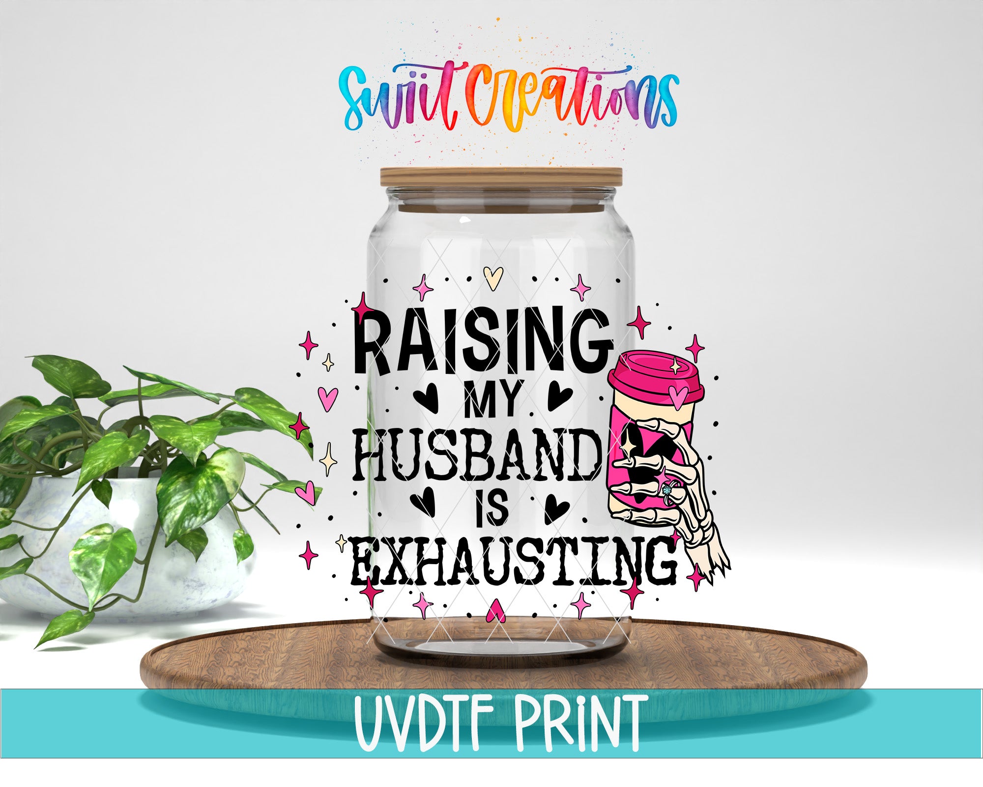 a glass jar with a printed message that reads "RAISING MY HUSBAND IS EXHAUSTING" along with a graphic of a skeleton hand holding a coffee cup. The jar is placed on a wooden surface, and there is a potted plant in the background.