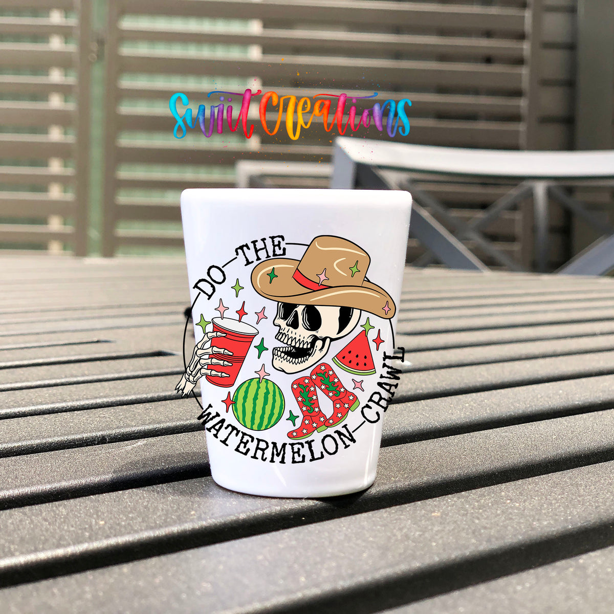 Do The Watermelon Crawl UV DTF transfer on a white shot glass on an outdoor patio table