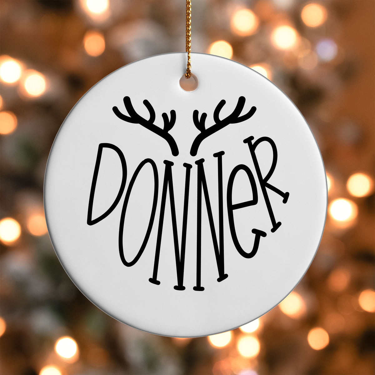 Donner Reindeer Name ornament UV DTF transfer on a round white ornament with a bokeh light background