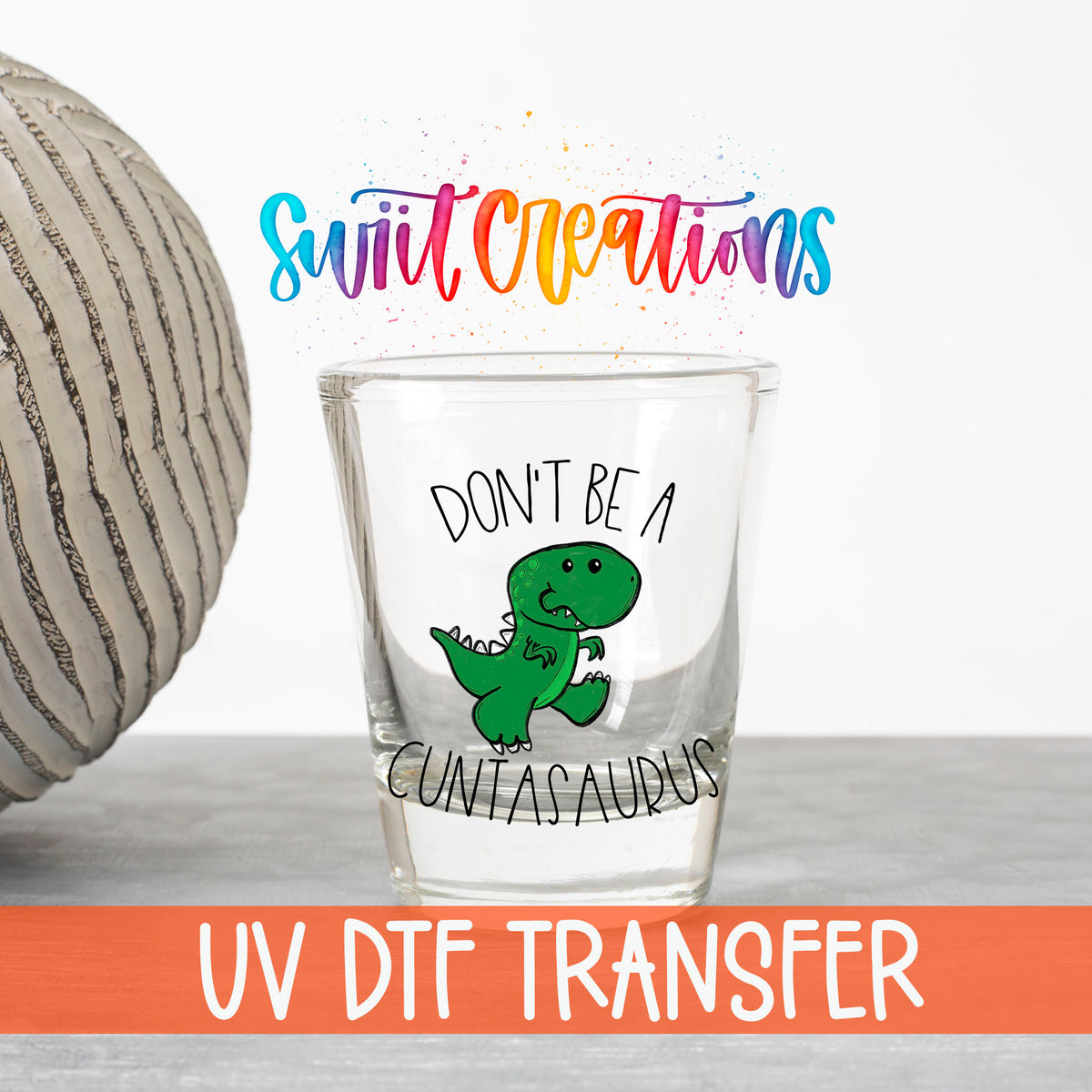 Don't Be a Cuntasaurus UV DTF transfer on a clear shot glass with the Swiit Creations logo and UV DTF Transfer banner