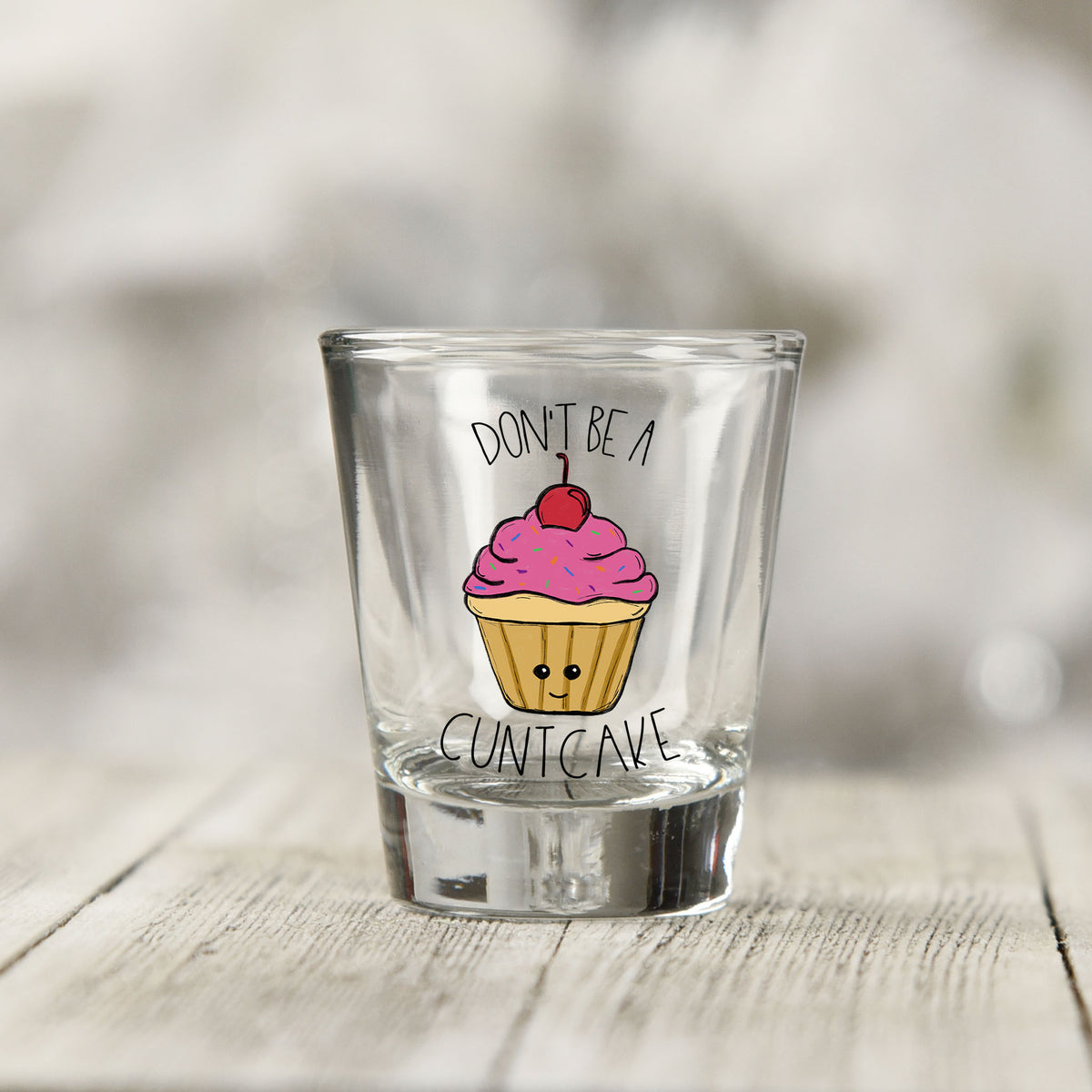 Close-up of the Don't Be a Cuntcake UV DTF transfer on a clear shot glass