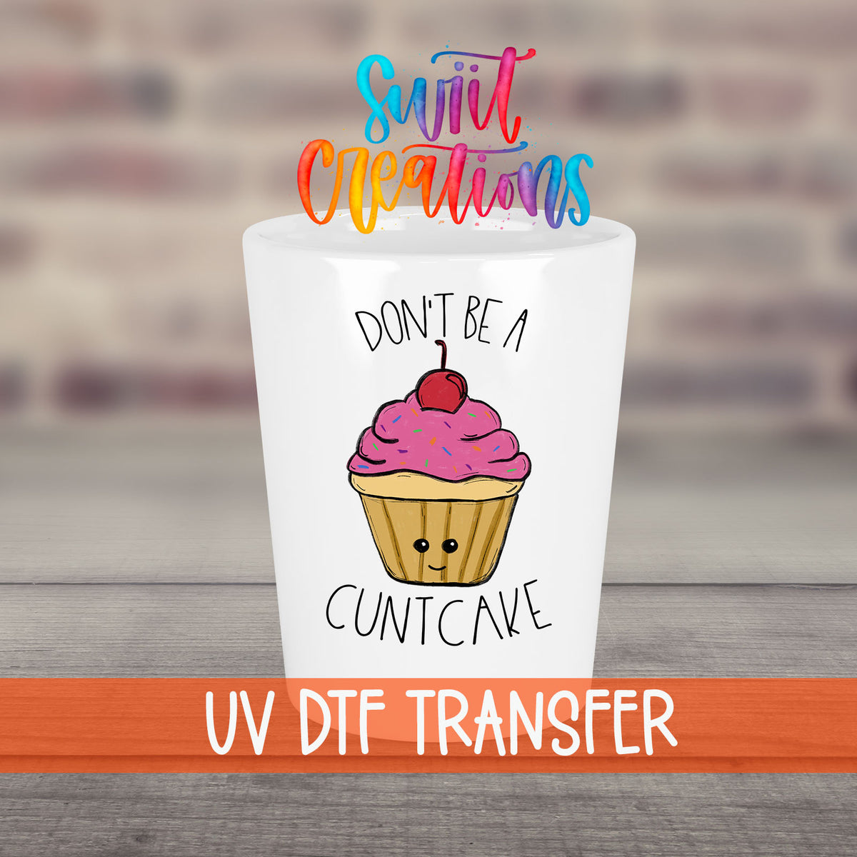 Don't Be a Cuntcake UV DTF transfer on a white shot glass in front of a brick wall