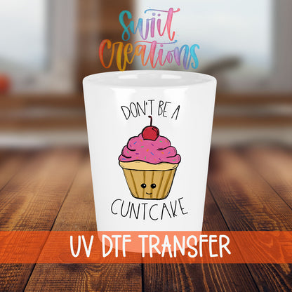 Don't Be a Cuntcake shot glass transfer on a white shot glass on a wooden table