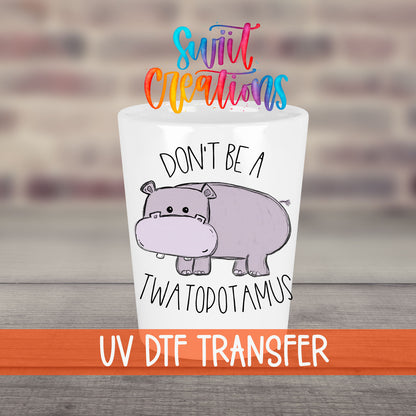 Don't Be a Twatopotamus UV DTF transfer on a white shot glass in front of a brick wall