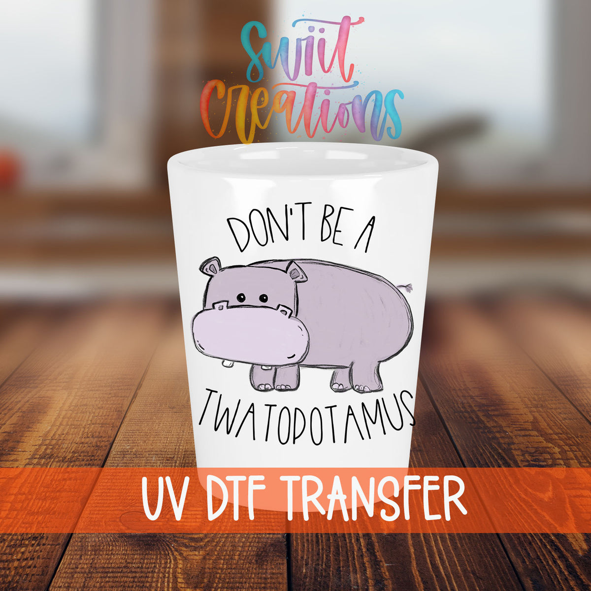 Don't Be a Twatopotamus shot glass transfer on a white shot glass on a wooden table
