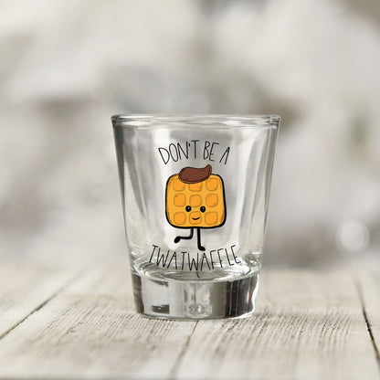Close-up of the Don't Be a Twatwaffle UV DTF transfer on a clear shot glass