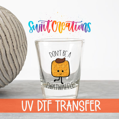 Don't Be a Twatwaffle UV DTF transfer on a clear shot glass with the Swiit Creations logo and UV DTF Transfer banner
