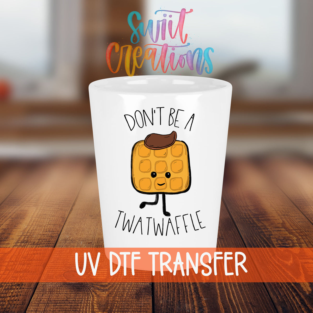 Don't Be a Twatwaffle shot glass transfer on a white shot glass on a wooden table
