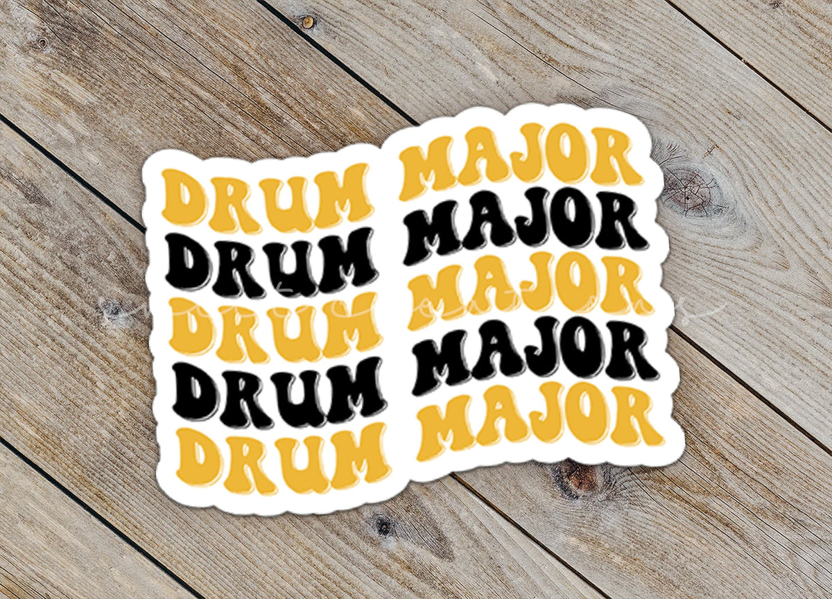 Close-up of the Black and Gold Drum Major sticker on rustic wood