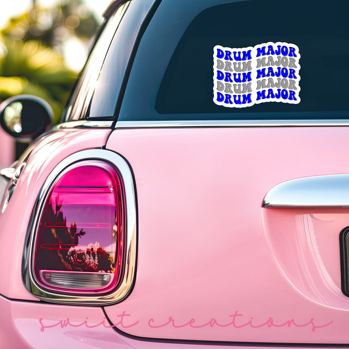 Blue and Silver Drum Major sticker on the back window of a pink car
