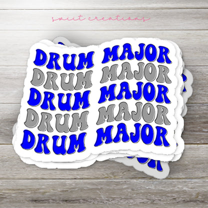 Stack of Blue and Silver Drum Major glossy stickers on a gray wood table