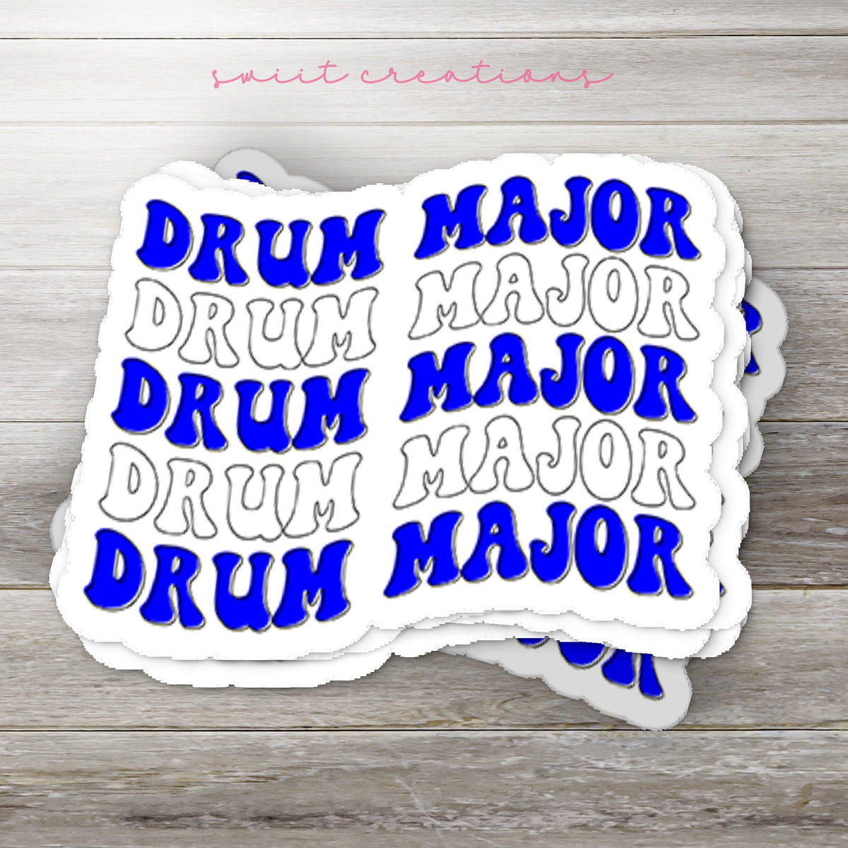 Stack of Blue and White Drum Major glossy stickers on a gray wood table