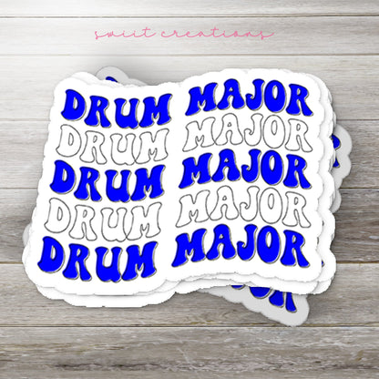 Stack of Blue and White Drum Major glossy stickers on a gray wood table