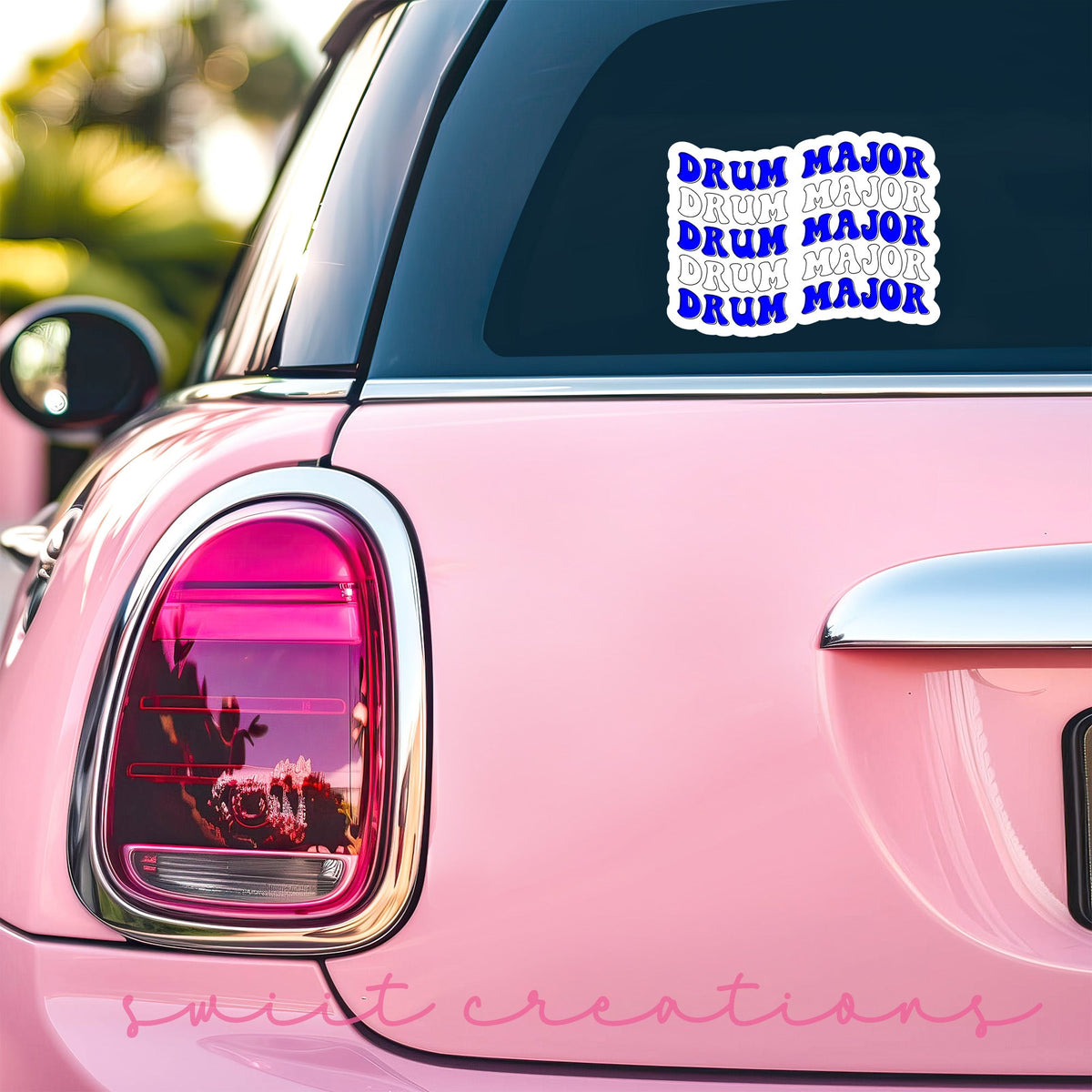 Blue and White Drum Major sticker on the back window of a pink car