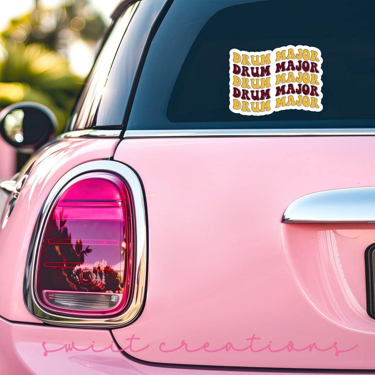 Maroon and Gold Drum Major sticker on the back window of a pink car