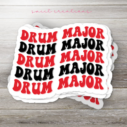 Stack of Red and Black Drum Major glossy stickers on a gray wood table