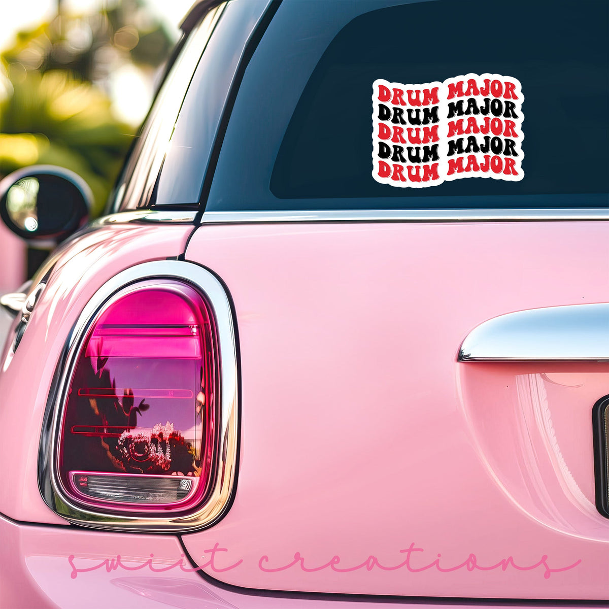 Red and Black Drum Major sticker on the back window of a pink car