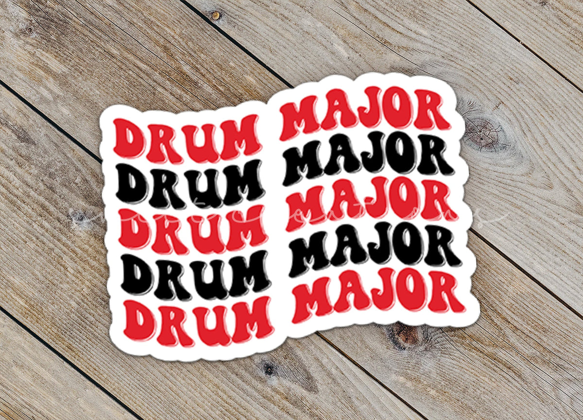 Close-up of the Red and Black Drum Major sticker on rustic wood
