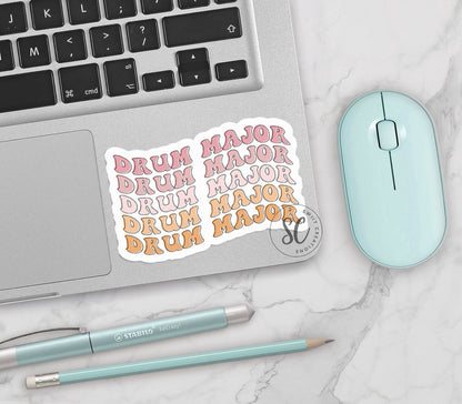 Retro Drum Major vinyl sticker on a silver laptop next to a mint mouse and pens