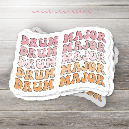 Stack of Retro Drum Major glossy stickers on a gray wood table
