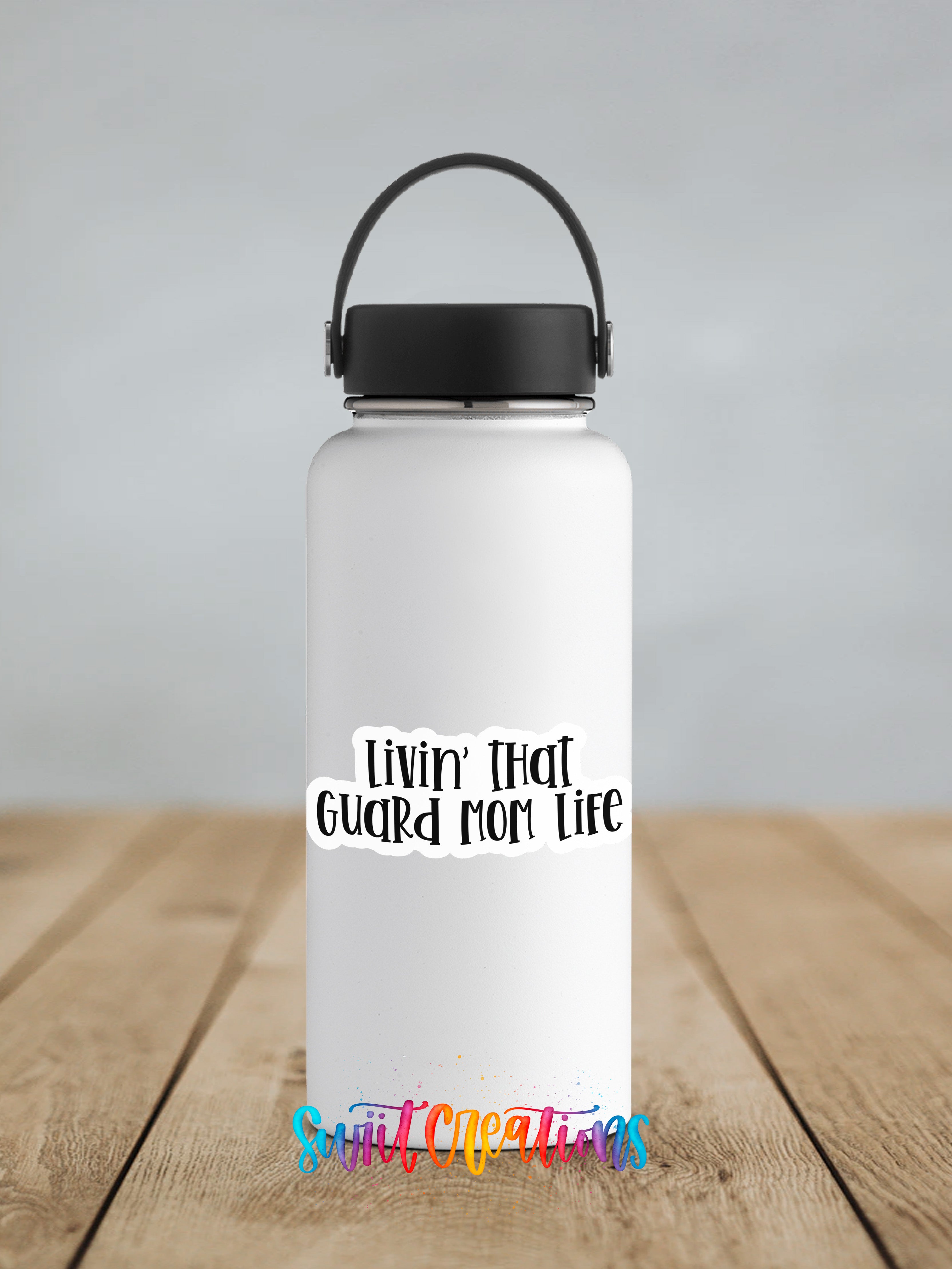 A white water bottle with a black handle and a black cap, featuring a colorful text sticker that says "Livin' That Guard Mom Life".