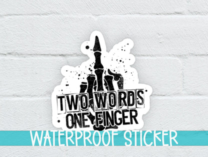 Two Words One Finger sticker on a white brick background with a waterproof sticker banner