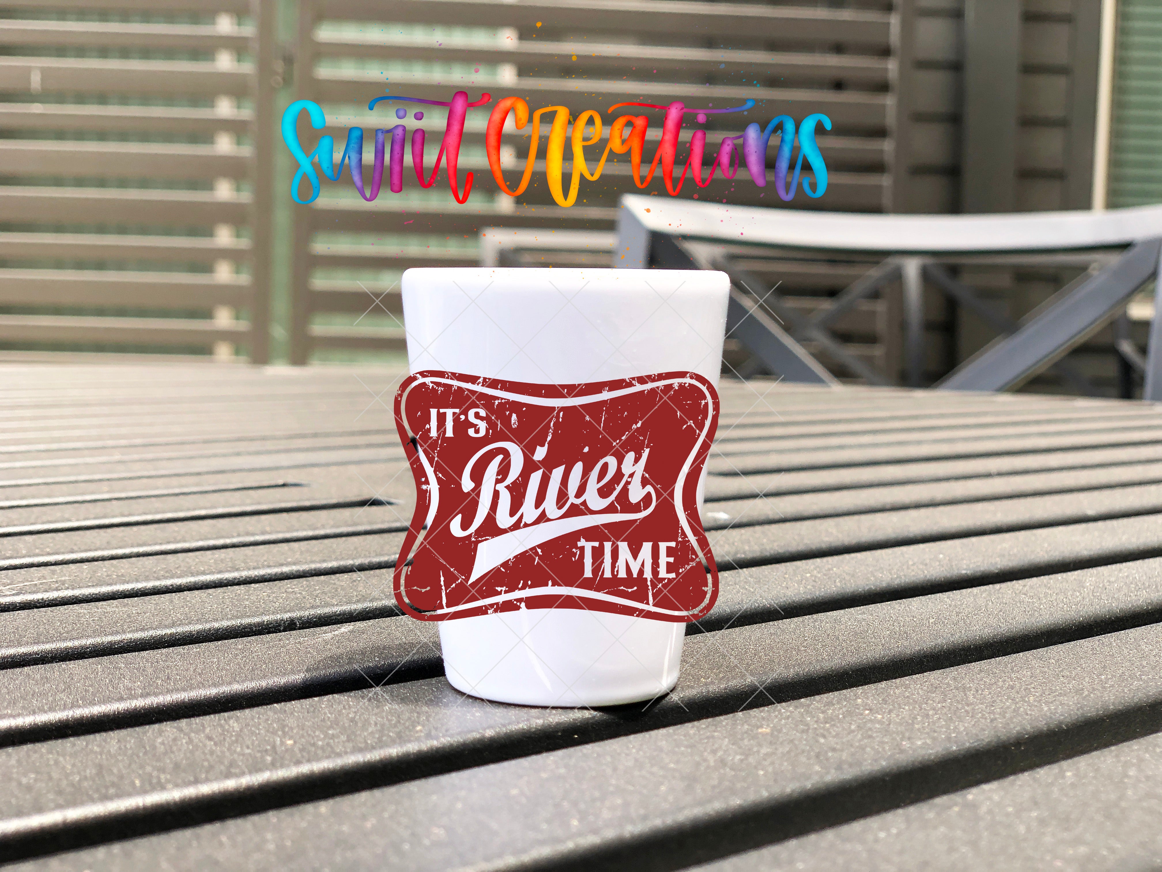 A white cup with a red and white sticker on it, placed on a metal bench.