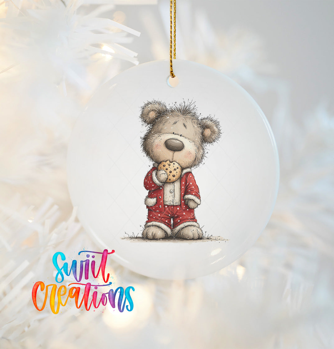 A white ornament featuring a teddy bear wearing a red outfit and holding a cookie.