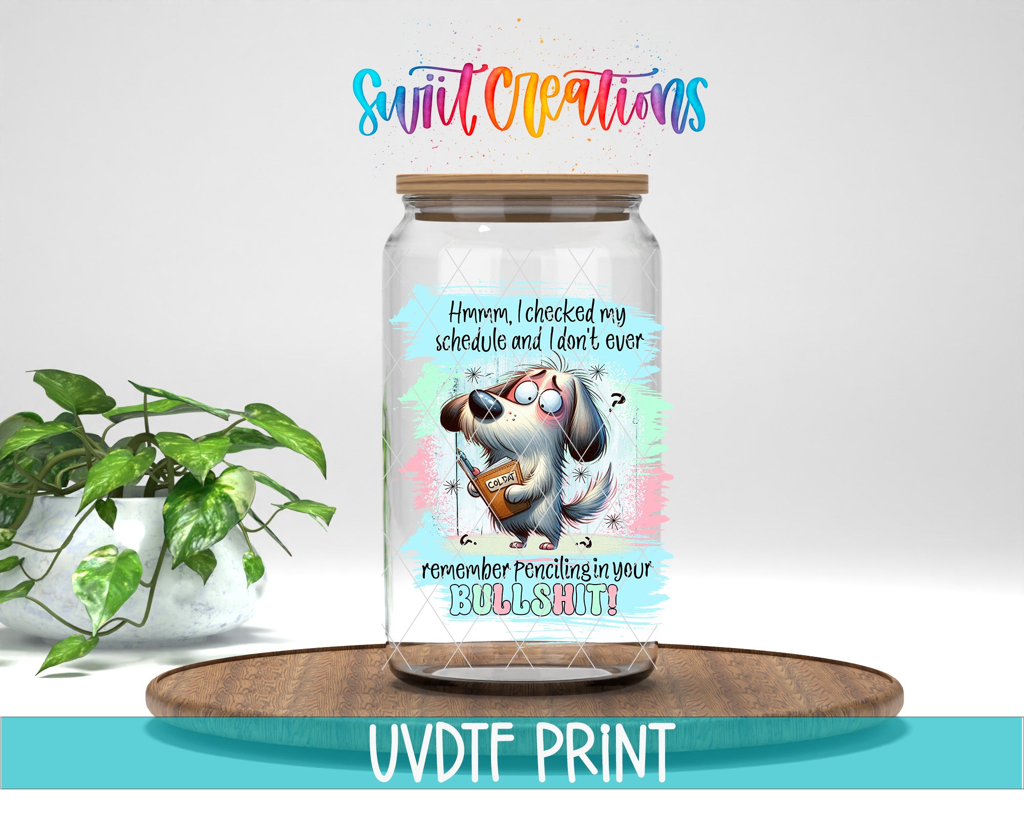 A glass jar with a cartoon dog and text on it, placed on a wooden surface next to a potted plant.