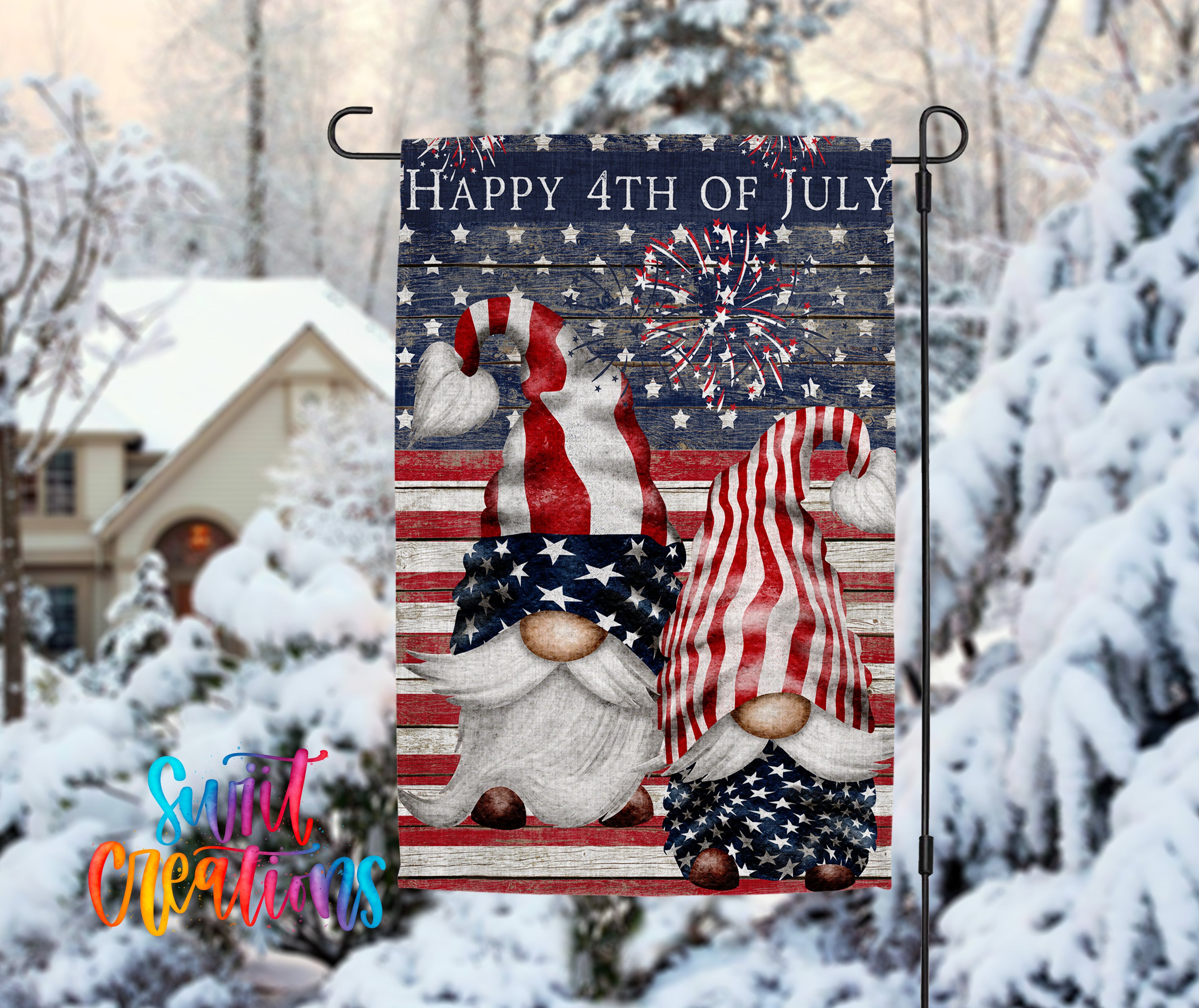 A patriotic flag featuring two gnomes wearing American flags and stripes, with a fireworks display in the background, is displayed in front of a snowy landscape with a house and trees.