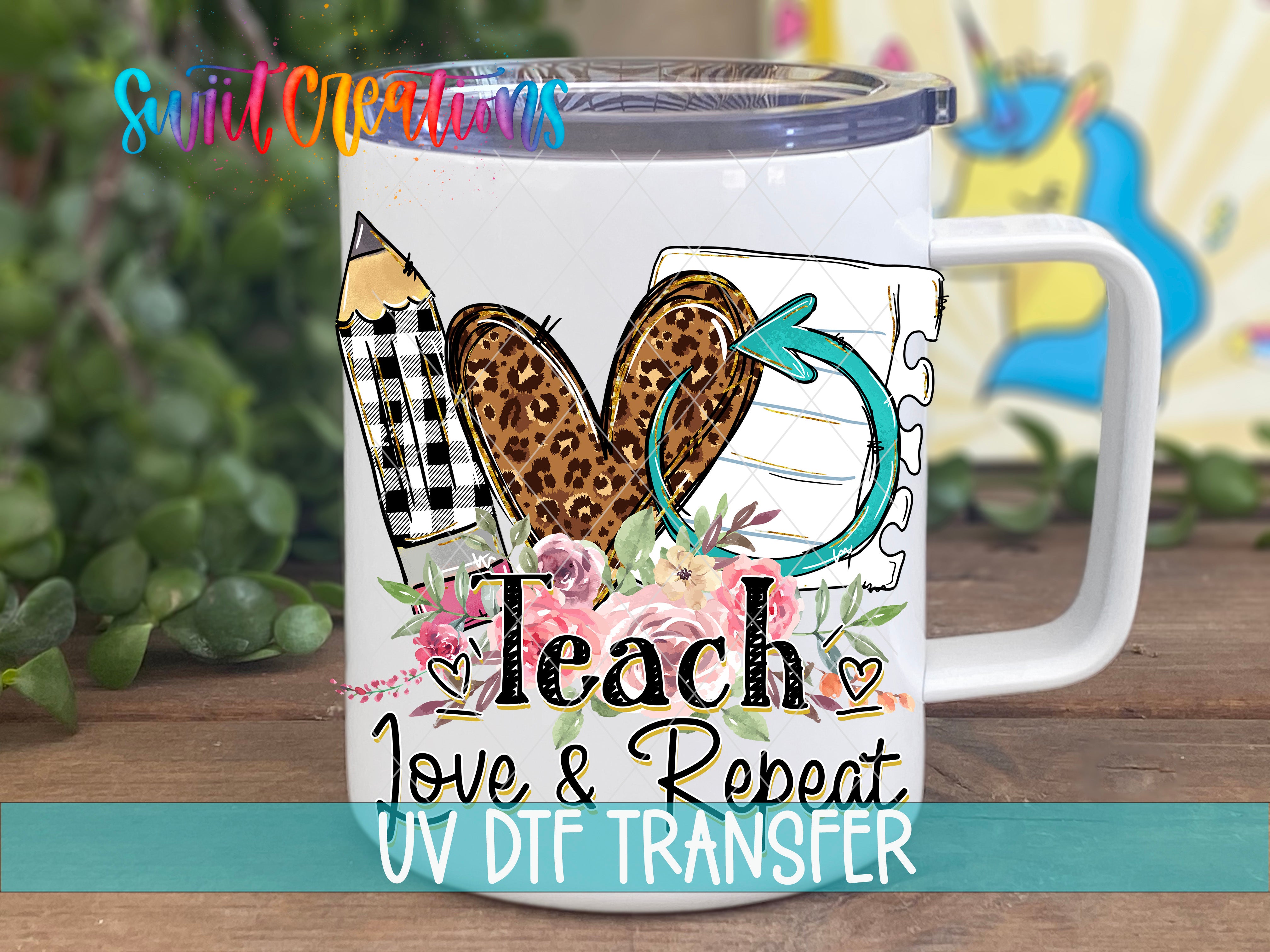 A white mug with a colorful design featuring a heart, pencil, and flowers, along with the text "Teach, Love & Repeat, UV DFT Transfers".