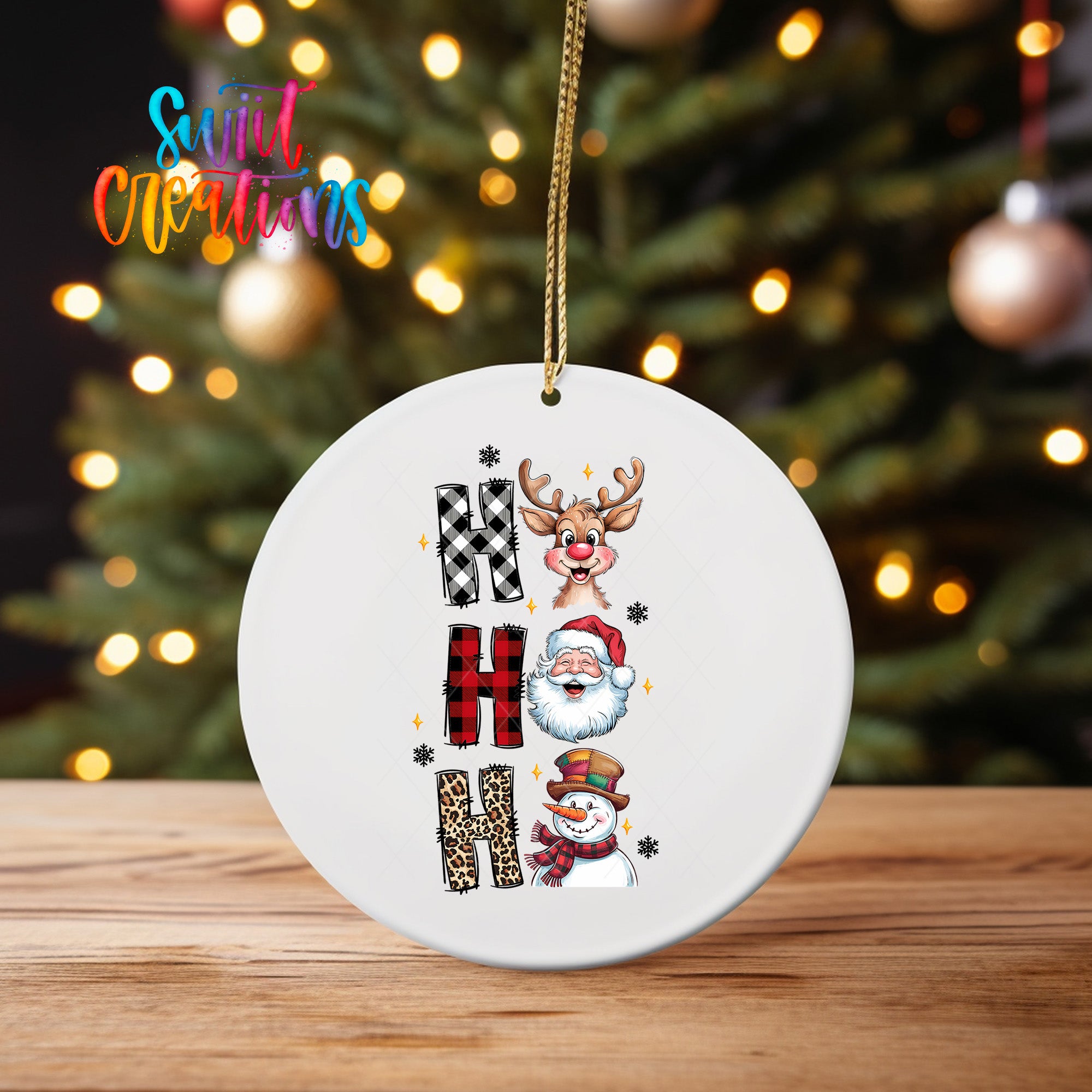 A white ornament with the word "NOM" written on it, featuring a reindeer, Santa Claus, and a snowman.
