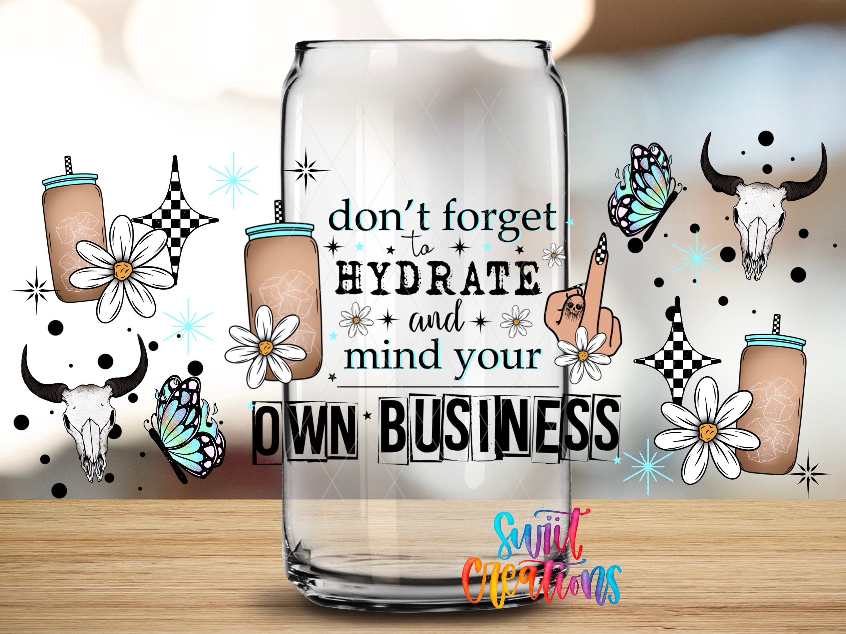 a clear glass can with a motivational quote and various decorative elements such as flowers, butterflies, and skulls.